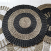 Handwoven circular seagrass rug with concentric rings in black dark gray and natural beige fibers