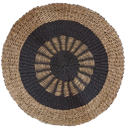 Circular seagrass rug with woven concentric design in natural beige and black textured fiber material