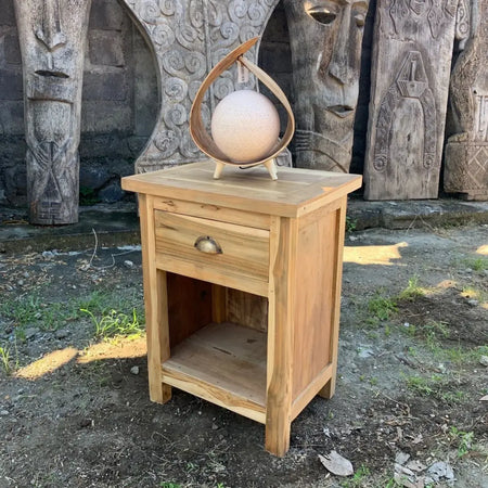 Light-colored wooden bedside table with a single drawer brass handle and open shelf made from recycled wood