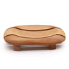 Light brown naseberry wood soap dish with smooth curved oval design and two small feet for bathroom use