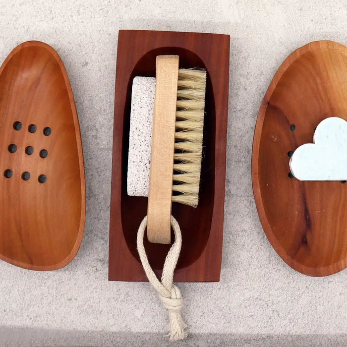 Wooden foot scrubber with natural bristles and stone exfoliating pad in a dark-stained naseberry wood soap dish holder