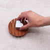 White heart-shaped soap resting on a round terracotta naseberry wood soap dish with slatted design