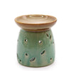 Classic oil burner with a green ceramic body featuring floral cutouts and a brown rimmed dish on top