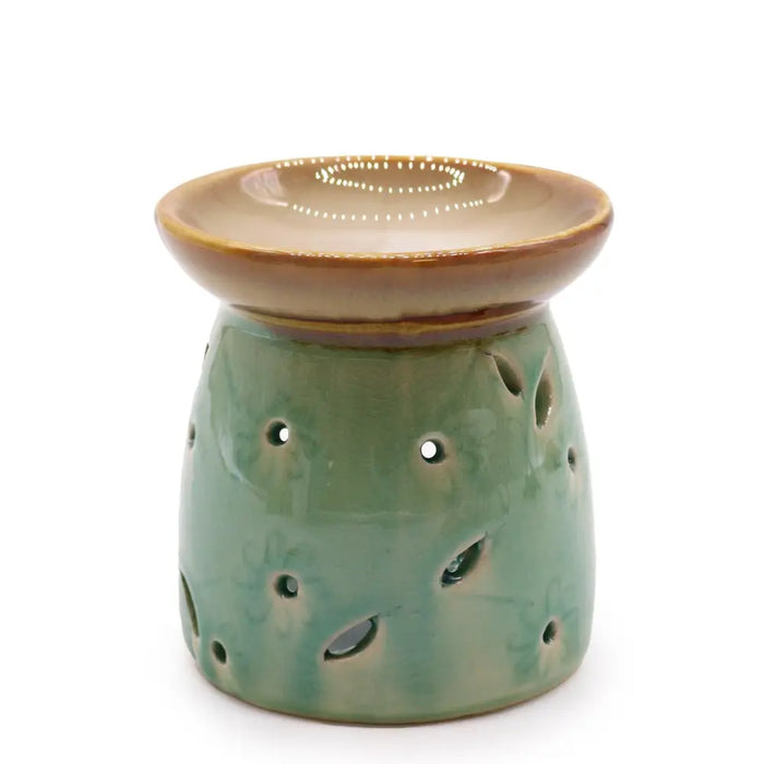 Classic oil burner with a green ceramic body featuring floral cutouts and a brown rimmed dish on top