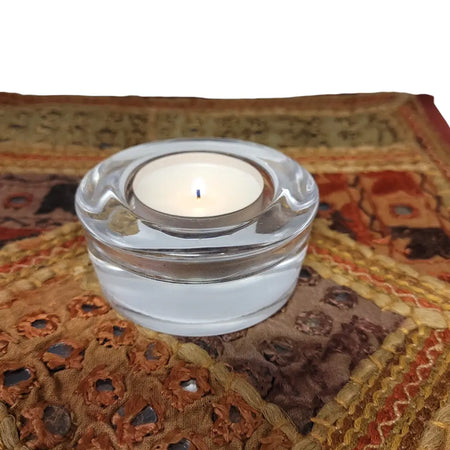 Clear glass tealight holder with smooth rounded rim and subtle horizontal ridges for glass tealight holders