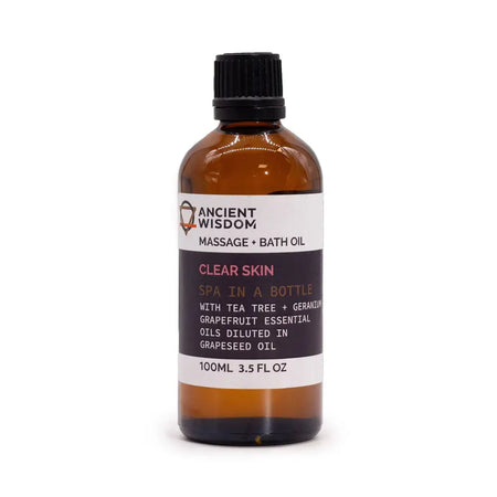 An amber glass bottle of clear skin massage oil with essential oils and a black ribbed cap for skin massage use