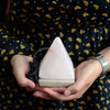 A white triangular usb crystal rock himalayan salt lamp with smooth translucent surface and black cord attached