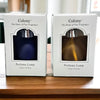 Two colony perfume lamps with cobalt blue and amber glass bodies in white boxes with silver tops for lamp oil use