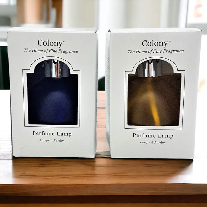 Two colony perfume lamps with cobalt blue and amber glass bodies in white boxes with silver tops for lamp oil use