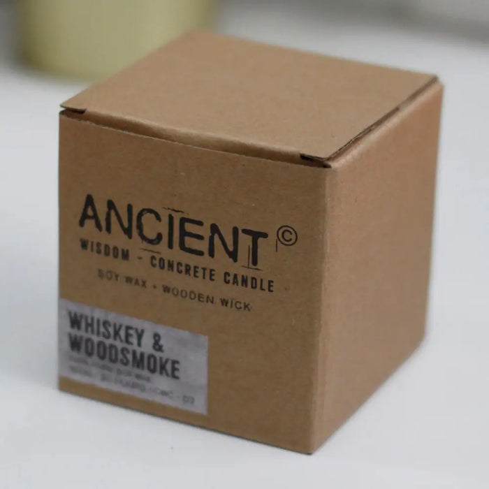 A brown cardboard box labeled ancient wisdom concrete candle with wooden wick and whiskey woodsmoke scent sticker