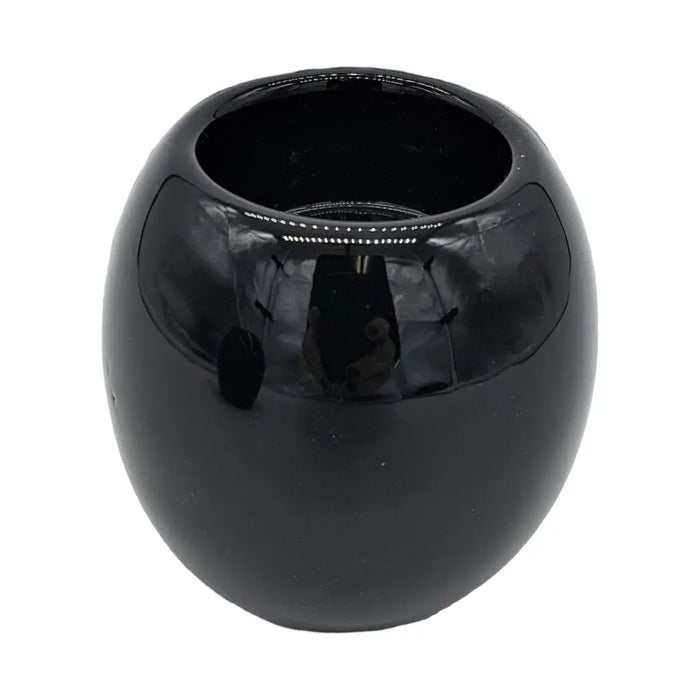 A sleek black ceramic tealight holder with a rounded bowl shape and smooth glossy surface