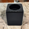 A contemporary black square ceramic tealight holder with a glossy finish and a circular opening on top