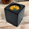 Contemporary black square ceramic tealight holder with a yellow lotus shaped ceramic tealight candle inside