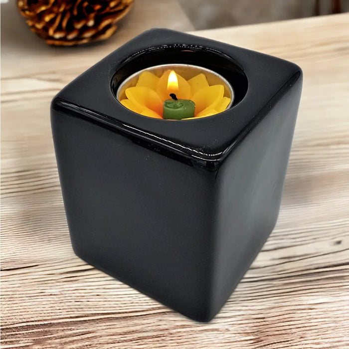 Contemporary black square ceramic tealight holder with a yellow lotus shaped ceramic tealight candle inside