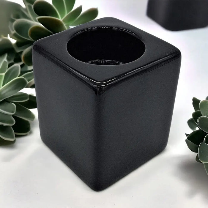 Contemporary black square ceramic tealight holder with glossy finish and rounded edges for tabletop use