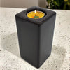 Contemporary brown square ceramic tealight holder with a lit yellow flower-shaped ceramic tealight inside