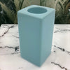 A pale blue ceramic tealight holder with a sleek square shape and smooth glossy finish high x 7cm