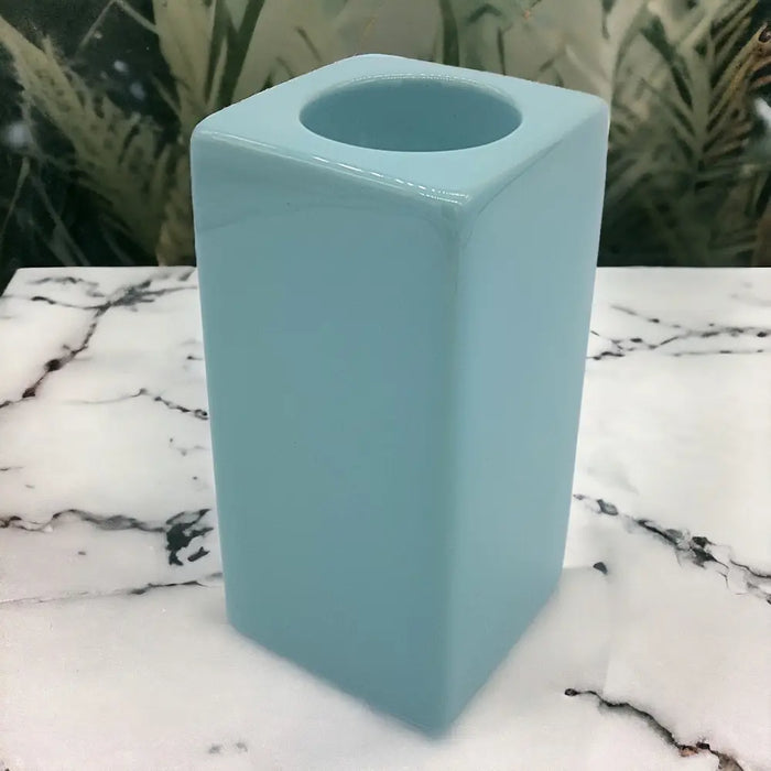 A pale blue ceramic tealight holder with a sleek square shape and smooth glossy finish high x 7cm