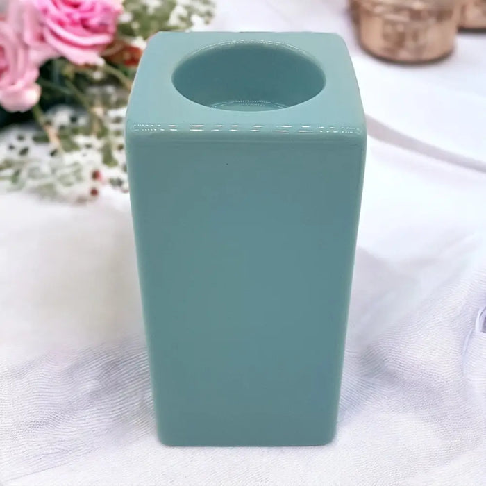 A sleek pale blue ceramic tealight holder with square shape matte finish and smooth edges high x 7cm