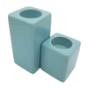 Two pale blue matte ceramic tealight holders in rectangular high x 7cm and cube shapes for modern decor