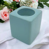A pale blue ceramic tealight holder with a matte finish square design and circular top opening high x 7cm