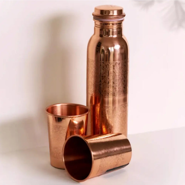 A sleek copper water bottle with engraved patterns and two matching cups gift set for warm water use