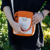 Orange and white cotton body bag with silver metal d-ring and zipper pull in a crossbody style called turmeric