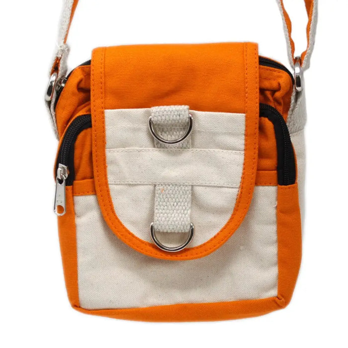 Orange and cream cotton canvas body bag with black zipper accents and silver metal hardware in turmeric color