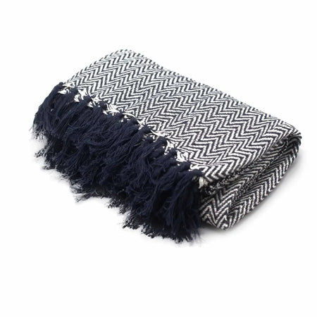 A folded navy cotton throw with white herringbone zigzag pattern and fringed edges called cotton comfort throw zigzag navy