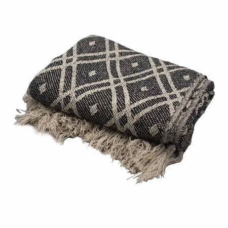 A folded black and cream geometric patterned cotton woven throw blanket with fringed edges from cotton comfort throws regency