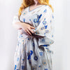 A flowing white cotton kaftan dress with blue and gold evil eye motifs v neckline and three quarter sleeves