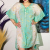 A sheer cotton kaftan dress in white and turquoise with gold fishes and front tassel ties
