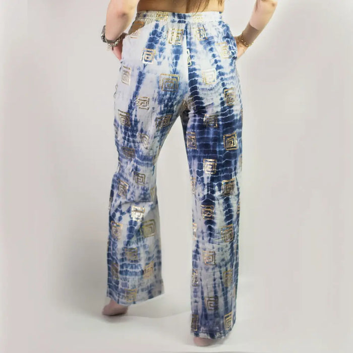 Blue and white tie-dye cotton lounge pants with wide-leg fit and gold geometric block print patterns