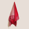 A cotton pario towel in hot pink with red and pink stripes and white fringe detailing