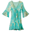 A turquoise cotton print dress with gold leaf patterns featuring bell sleeves and tiered ruffles in bohemian style