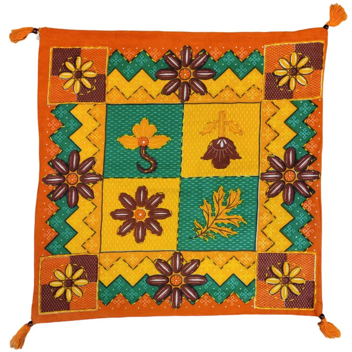 Vibrant orange cotton printed cushion cover with embroidered floral and geometric patterns and tassels on a standard cushion