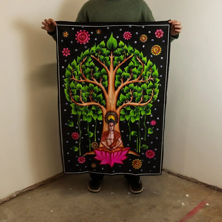 A vibrant black cotton wall tapestry showing buddha in lotus under a green bodhi tree with pink and yellow flowers
