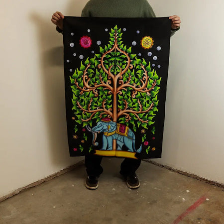 Vibrant cotton wall art featuring a stylized tree of life with green leaves pink and yellow flowers on black tapestry