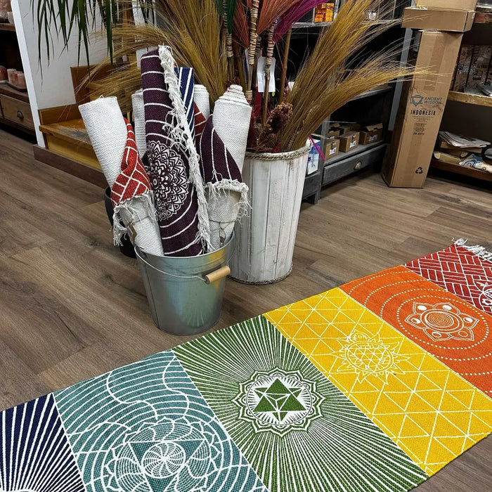 A vibrant cotton yoga rug with 7 chakras design in orange yellow green blue and red geometric mandala patterns