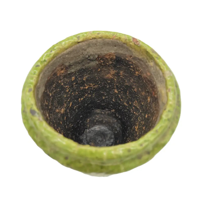 A weathered green terracotta plant pot with a crackle glaze, textured chips, and a rust-stained interior