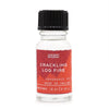 A clear glass bottle with black cap and red star label of ancient wisdom crackling log fire fragrance oil 10ml