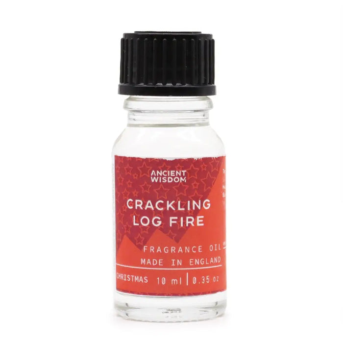 A clear glass bottle with black cap and red star label of ancient wisdom crackling log fire fragrance oil 10ml