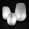Three crystal rock himalayan salt lamps in pale gray with natural shapes showing their hygroscopic properties