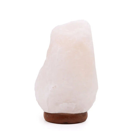 A smooth translucent pink himalayan salt lamp sitting on a natural stone base weighing 2 to 3 kilograms