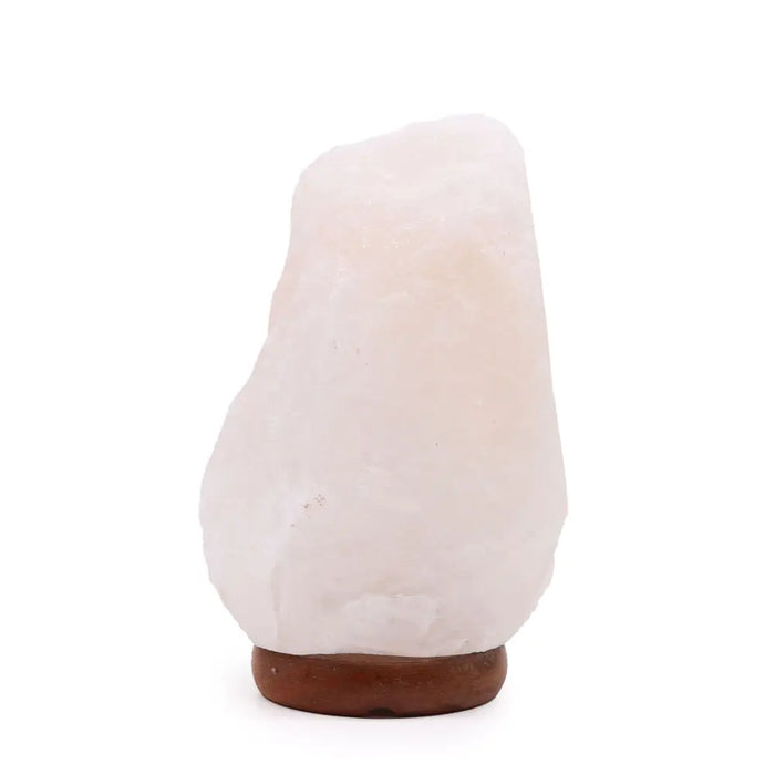 A smooth translucent pink himalayan salt lamp sitting on a natural stone base weighing 2 to 3 kilograms