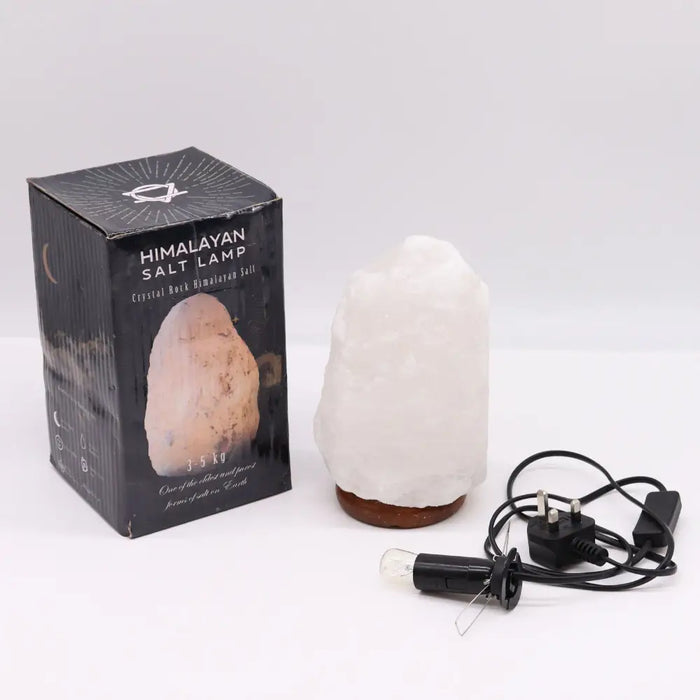 A white crystal rock himalayan salt lamp with rough texture and brown ceramic base showing hygroscopic properties