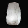 A glowing white crystal rock himalayan salt lamp with rough texture and subtle gray veining showing hygroscopic properties