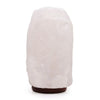 A translucent white crystal rock himalayan salt lamp with rough texture and dark brown base showing hygroscopic properties