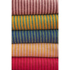 Stacked striped throws in recycled cotton with pale pink mustard and vibrant earthy tones and bold hues