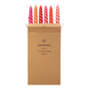 Set of six twisted dinner candles in gradient pink to orange made with coconut oil in a brown kraft box by daisy snow